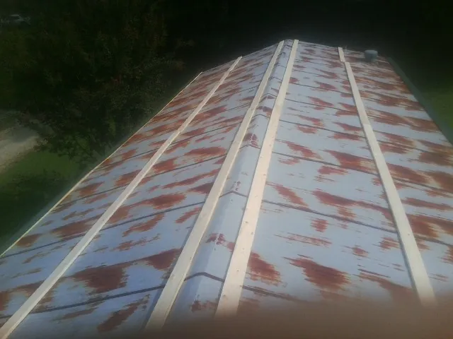 Rusted metal roof panels with new wood purlins before replacement — Storm Damage Roof Repair in Bird Island by Roofing Brothers