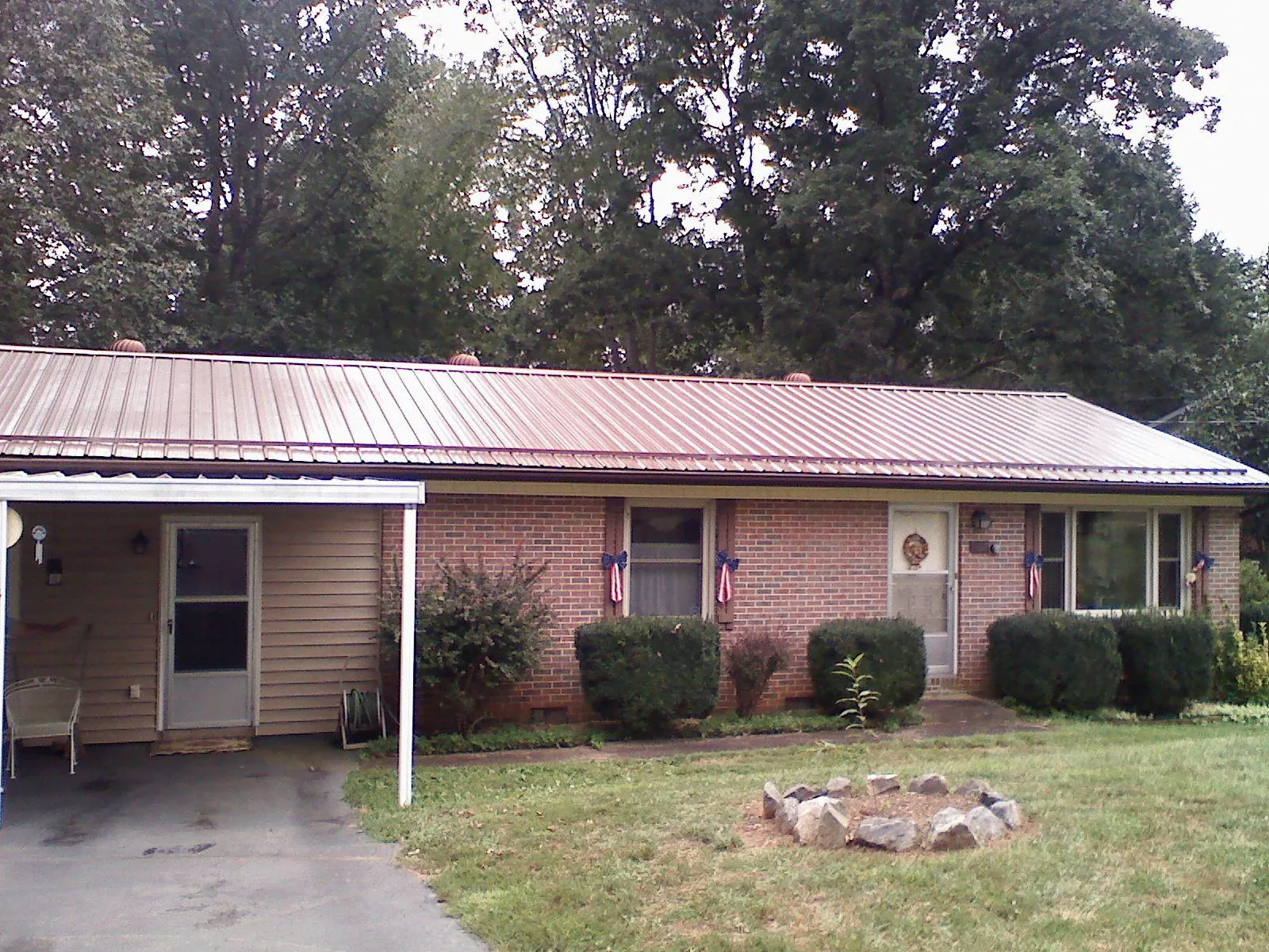 Bronze metal roof and carport on a brick ranch home — Roof Repair work by our crew in Bird Island